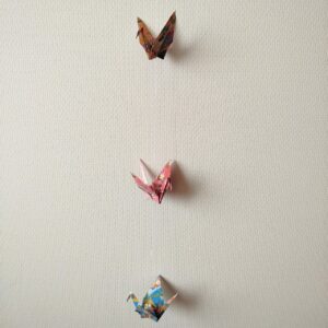 Colorful Japanese origami crane mobile with three connected cranes made from Yuzen chiyogami paper